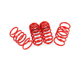 Group of red metal coil springs standing upright on a white surface